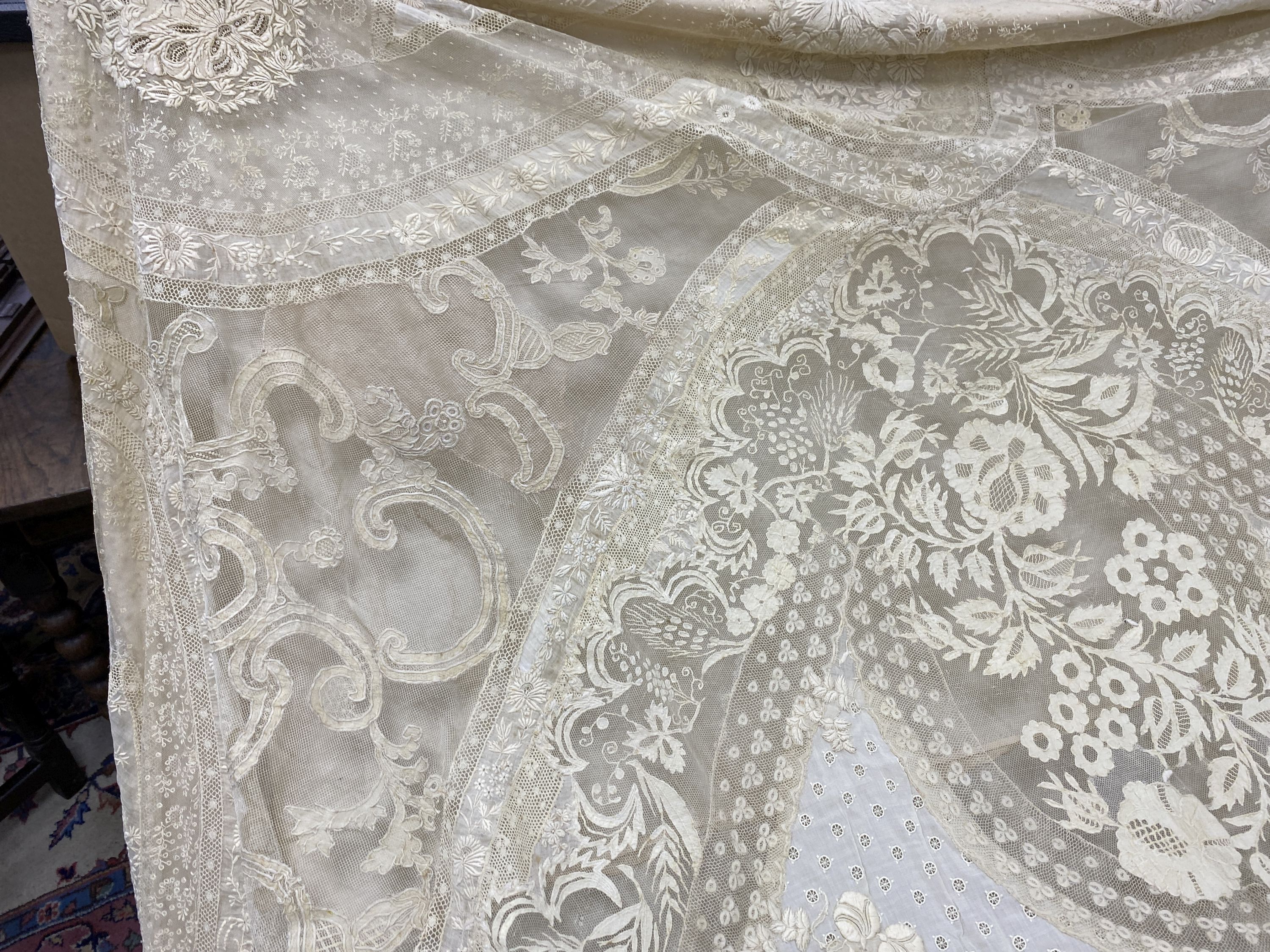 An Edwardian hand made lace bedspread. Hand sewn using finely spun lawn, decorated with Carrickmacross and white work embroidery, edged in bobbin lace. Possibly made as part of a trousseau.